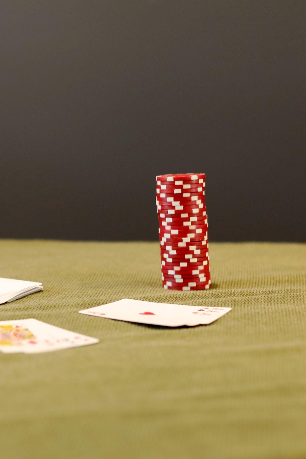 Chip poker merah di atas meja kain hijau sebagai ilustrasi rakeback poker Oyo777